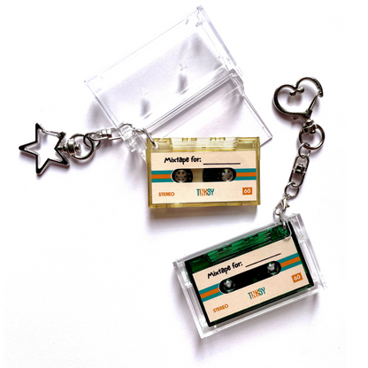 Cassette tape keychains with clear cases and heart-shaped charm on a white background