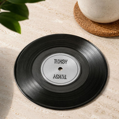 A black vinyl record-shaped coaster
